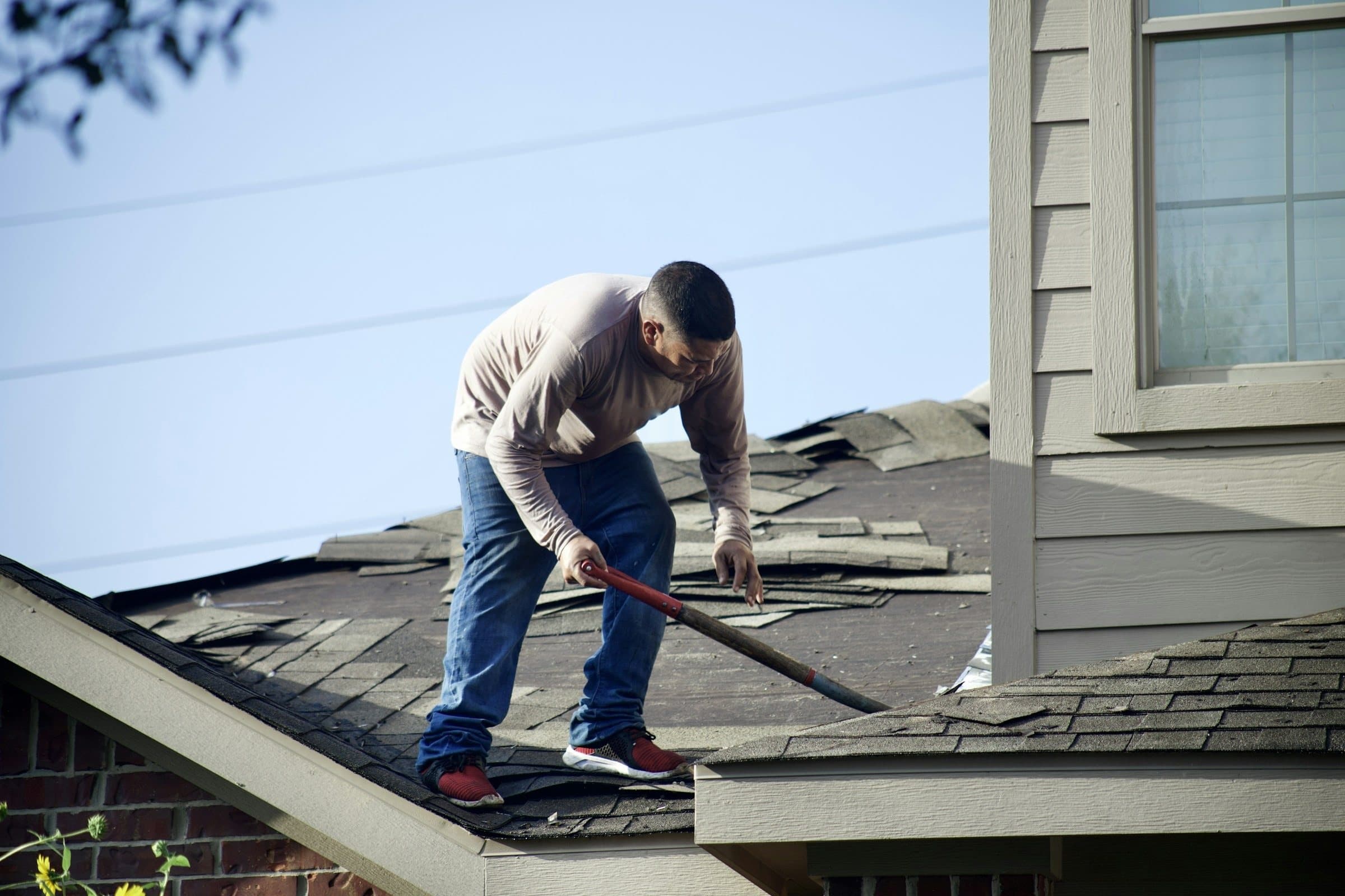 A roofing crew tearing off old asphalt shingles